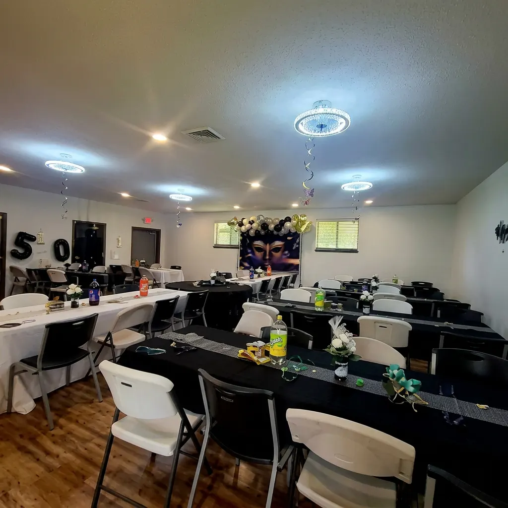 Hall set with black-linen banquet tables after an event.